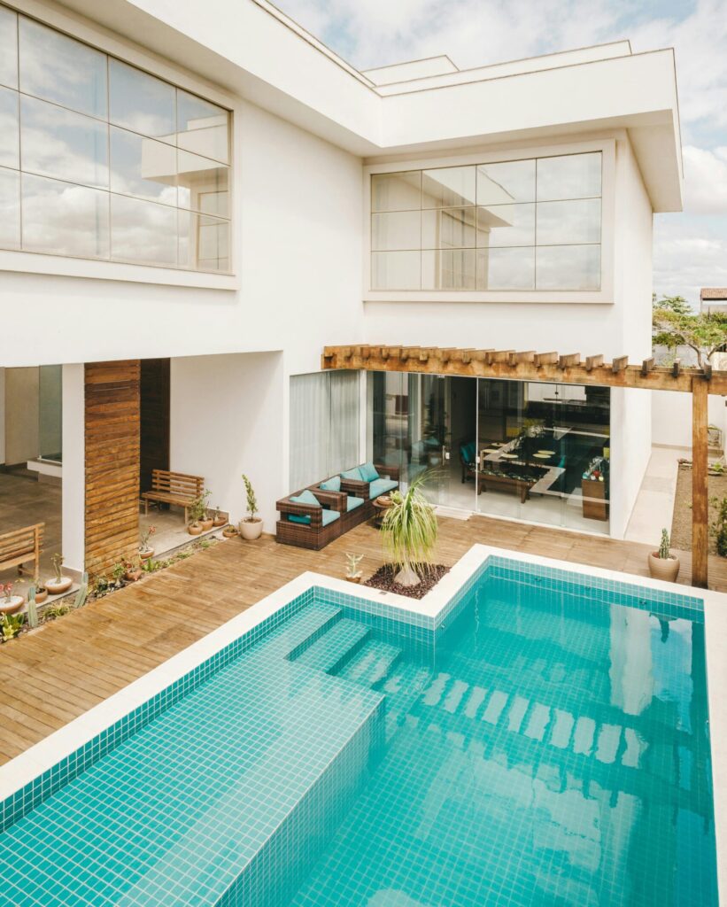 Contemporary interior of lounge area with swimming pool located on terrace of luxury villa in sunny day