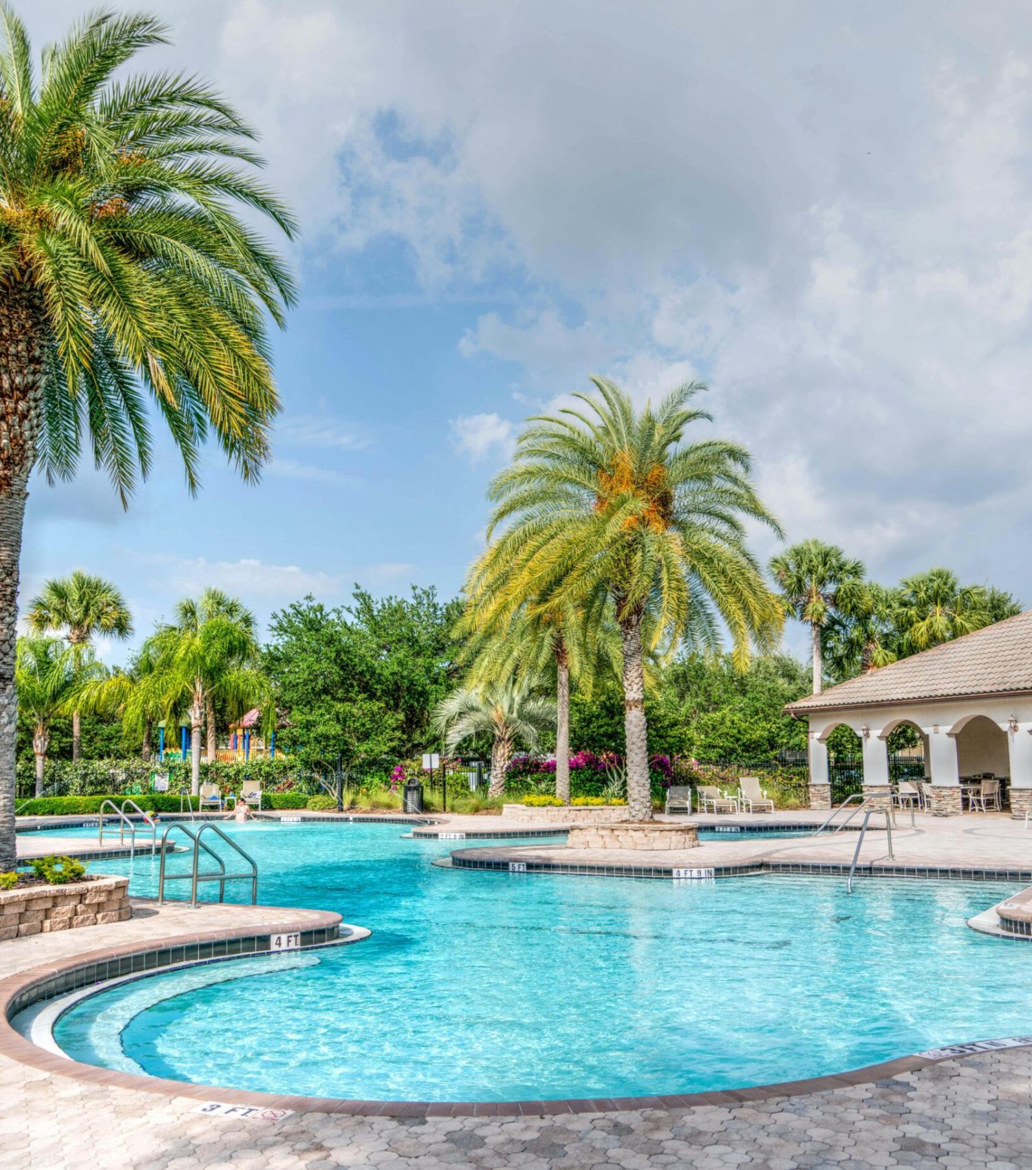 Idyllic tropical resort featuring palm trees, tranquil poolside setting, and relaxing vacation vibes.